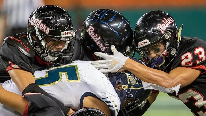 The Iolani Raider defense corrals Waipahu running back Alfred Failauga