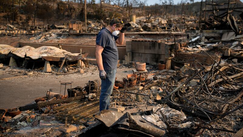 Kevin Marshall sifts through his mother's fire-ravaged property in the the Palisades Fire in...