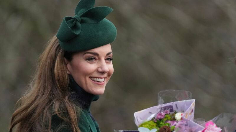 Kate Princess of Wales smiles as holds a bouquet of flowers gives to her by well-wishers after...