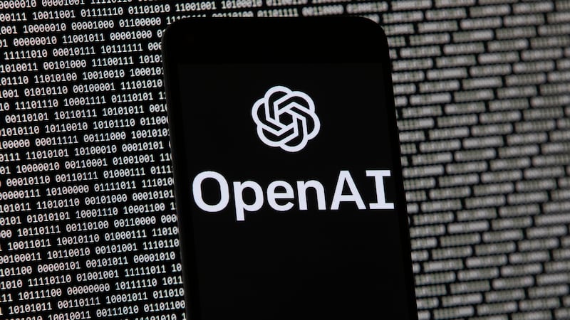 FILE - The OpenAI logo appears on a mobile phone in front of a computer screen with random...