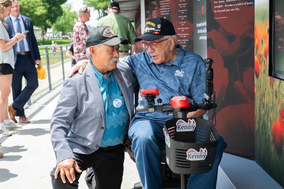 Allen Hoe, Vietnam combat veteran, and Patriotic Kenny, Navy veteran, embrace at the USAA...