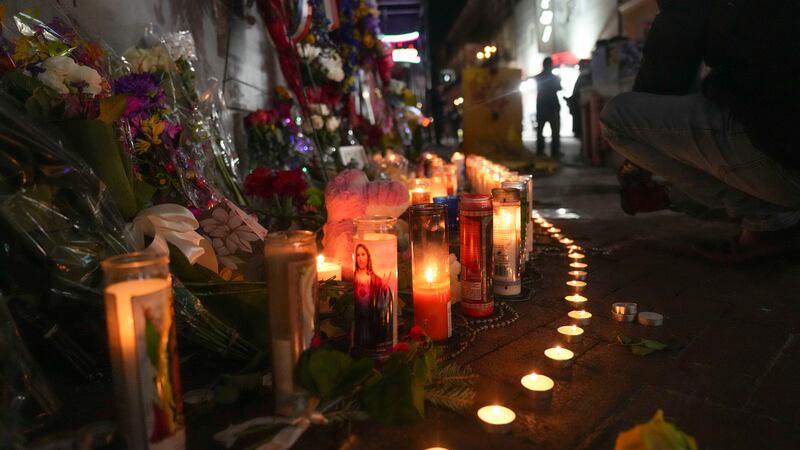 Flowers and votive candles line a memorial for the victims of a deadly truck attack on New...