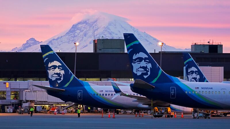 FILE - Alaska Airlines planes are shown parked at gates with Mount Rainier in the background...