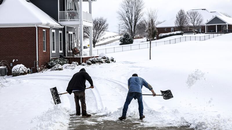 Joe Huff, left, and Kenny Braden with "The Yard Barber" work to clear snow from the driveway...