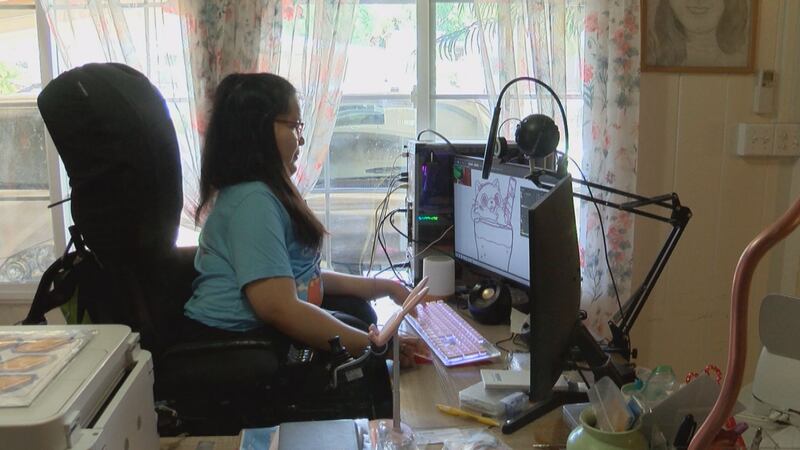 Janelle Fiesta works on designing stickers for her business.