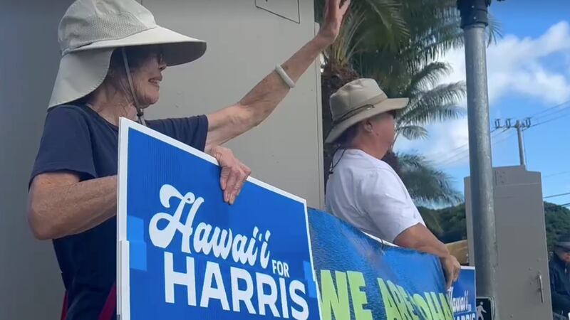 Supporters wave "Hawaii for Harris" signs in Honolulu on Monday.
