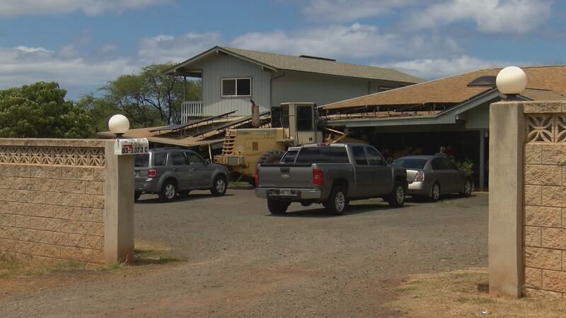 Front loader used in mass shooting remains pinned under roof.