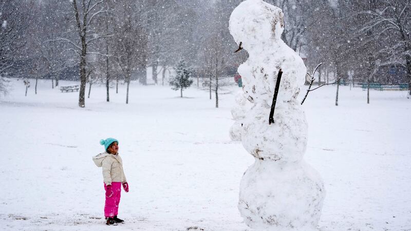 Brooklyn Brye, 4, looks up at giant snowman, in Nashville, Tenn., Friday, Jan. 10, 2025. (AP...