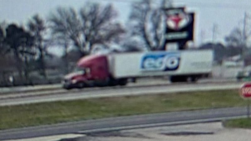 The semi-truck has the word “ego” marked on the trailer and has a maroon-colored cab.