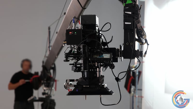 A film camera is lifted over a movie shoot. The image illustrates the behind-the-scenes work...