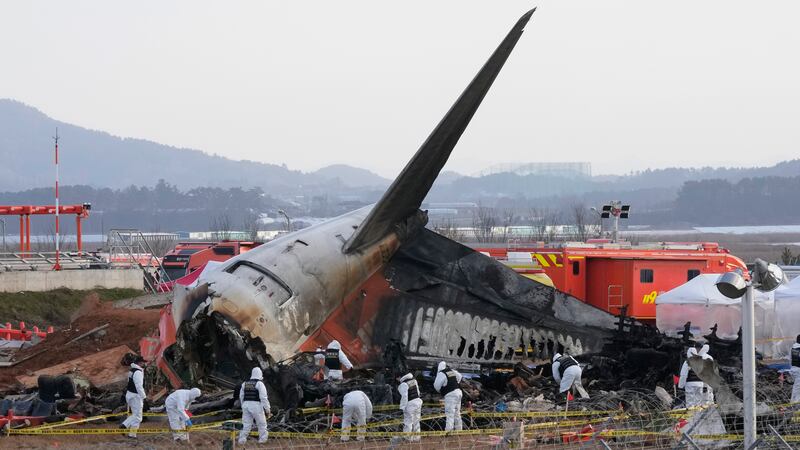 FILE - Rescue team members work at the site of a plane crash at Muan International Airport in...