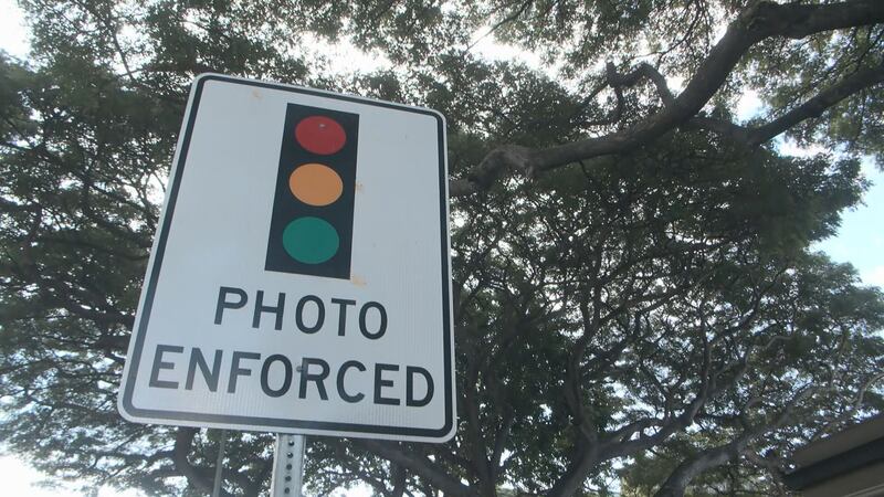 A sign warns drivers of a red light camera ahead.