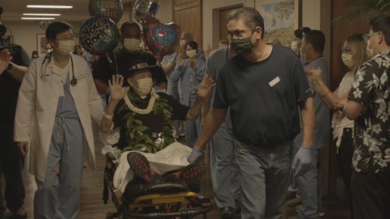 Wearing maile, pikake, and his signature black hat, Jack Denis waved to the hospital staff who...