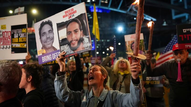 Demonstrators hold torches during a protest calling for the immediate release of the hostages...