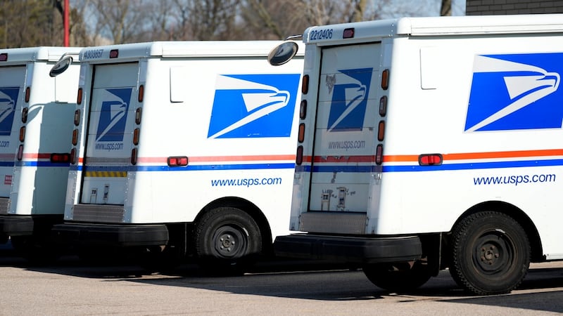 FILE - U.S. Postal Service trucks park outside a post office in Wheeling, Ill., Monday, Jan....