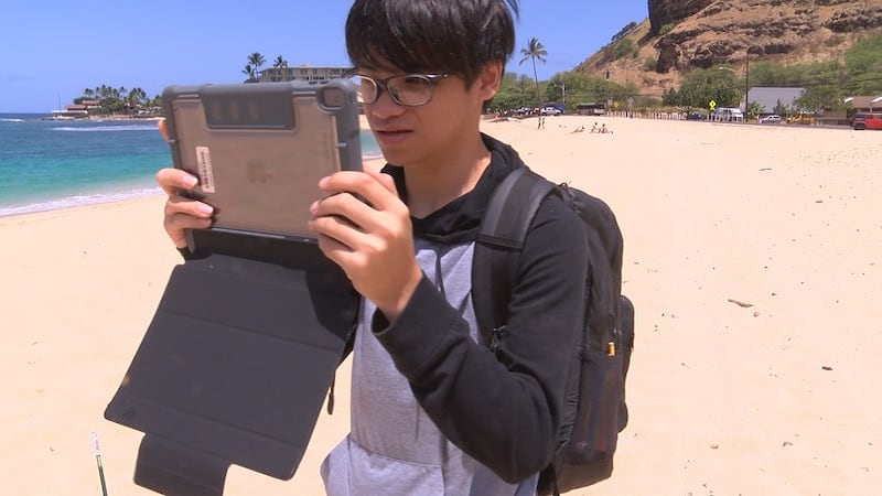 Using tape measures and drones, a group of students from Waianae High School gathers data on...