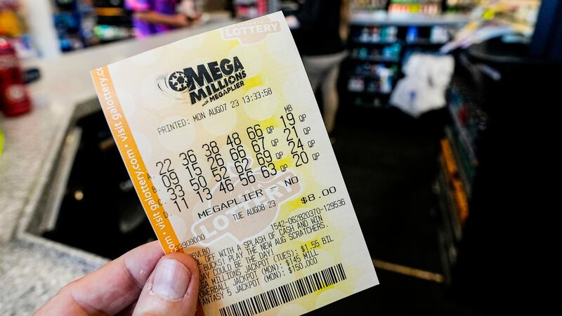 FILE - A Mega Millions ticket is seen as a person makes a purchase inside a convenience store,...